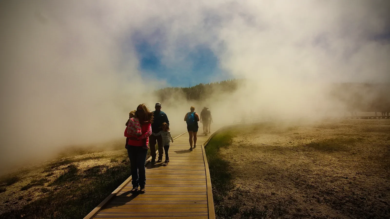 Families walk through geyser steam in Yellowstone National Park. Photo: Envato